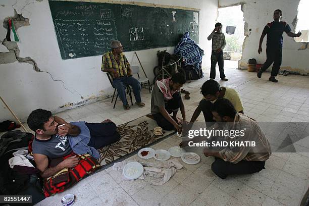 Egyptians stranded in the Gaza Strip due to the closure of the crossing between southern Gaza and Egypt, share a meal at a school in the border town...