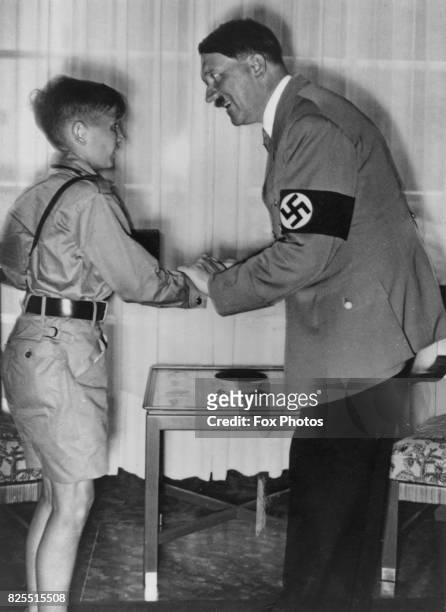 German Chancellor Adolf Hitler talking to a young boy, circa 1939.