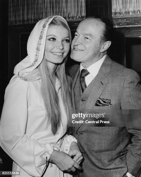 American comedian Bob Hope receives a kiss from Miss World 1969, Eva Rueber-Staier, at the New Victoria Theatre in London, 5th December 1969. She is...