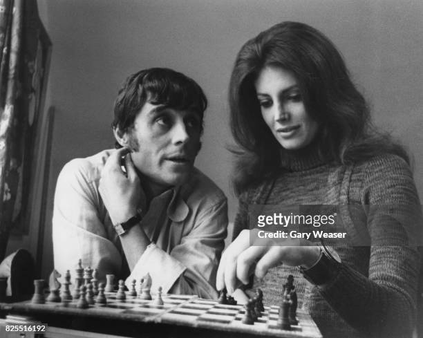American actress Gayle Hunnicutt playing chess with actor Ian McShane, her co-star in the film 'Freelance', between takes at a house in Muswell Hill,...