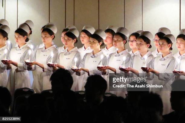 Nurses hold candles during the Florence Nightingale Medal Ceremony on August 2, 2017 in Tokyo, Japan.