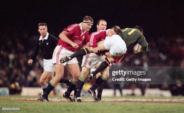 South Africa winger Andre Snyman is tackled by Scott Gibbs during the First Test Match between South Africa and British and Irish Lions at Newlands...