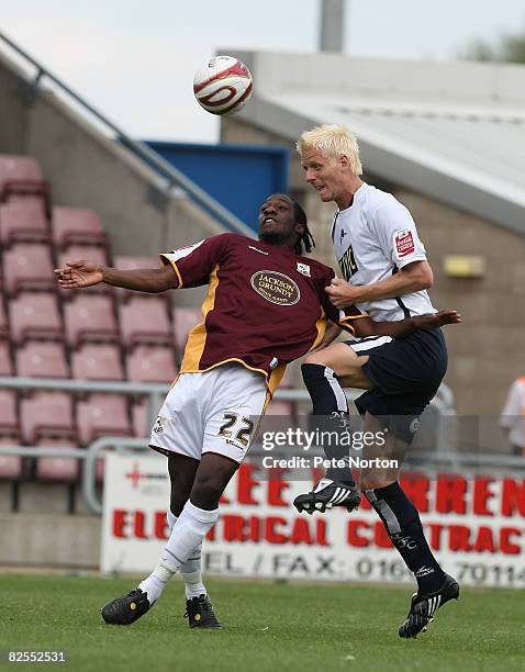 Zak Whitbread of Millwall heads the ball away from Joe Benjamin of Northampton Town during the Coca Cola League One Match between Northampton Town...