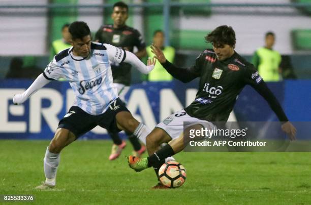 Luis Francisco Rodriguez of Bolivia's Oriente Petrolero vies for the ball with Tomas Cuello of Argentina's Atletico Tucuman during a Copa...