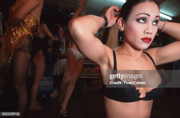 Transexuals and transvestites adjust their costumes backstage before a cabaret show at a nightclub in Soi 4 off Silom Road in downtown Bangkok....