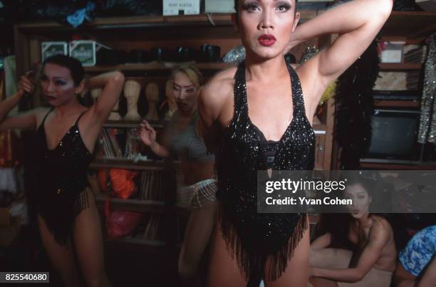 Thai transsexual performer adjusts her costume before going on-stage for a show at a nightclub in Bangkok. Transsexuals, or Katoeys as the Thais call...