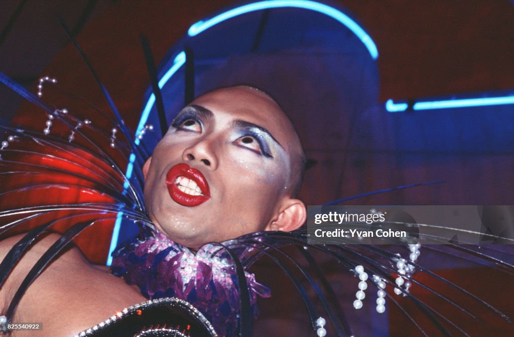 A transvestite with a shaved head and wearing heavy make-up...