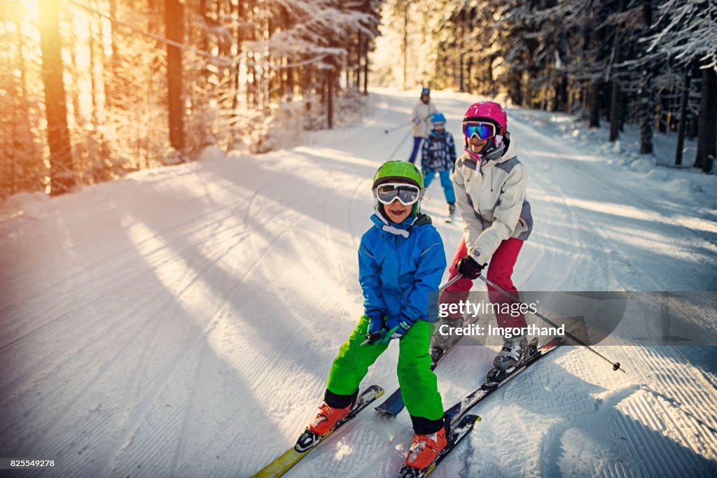 Famille s’amusant ski ensemble le jour de l’hiver