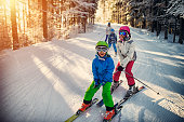 Family having fun skiing together on winter day