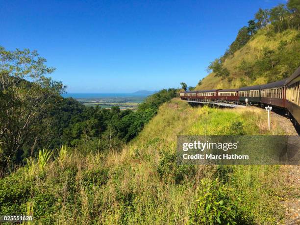 scenic view of a train passing along a hillside - marc hathorn stock-fotos und bilder