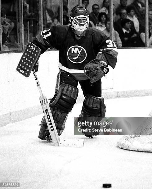 Billy Smith of the New York Islanders plays puck behind net in game against the Boston Bruins at the Boston Garden.