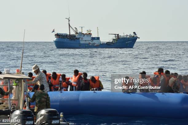 Picture taken on November 4, 2016 migrants and refugees sitting on a rubber boat as the Libyan coastguards patrol help them during a rescue operation...