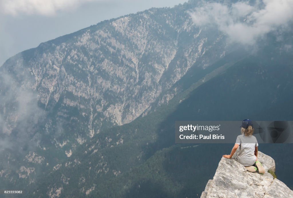 Boy hiker looks off from high ridge crest, Mount Olympus, home of the gods of ancient Greece