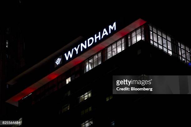 Signage is illuminated at night on the top of a Wyndham Grand Chicago Riverfront Hotel in downtown Chicago, Illinois, U.S., on Friday, July 28, 2017....