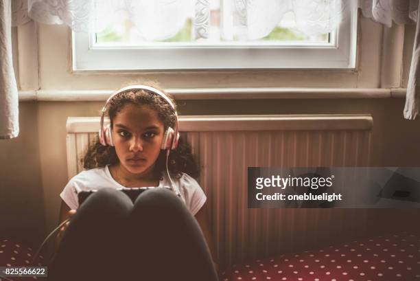infantil (11-12) escuchando música - onebluelight fotografías e imágenes de stock