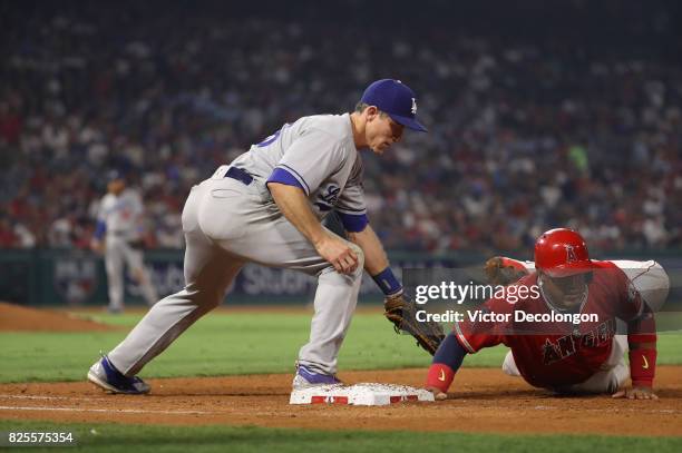 Yunel Escobar of the Los Angeles Angels of Anaheim dives back to first base before the tag of first baseman Chase Utley of the Los Angeles Dodgers...