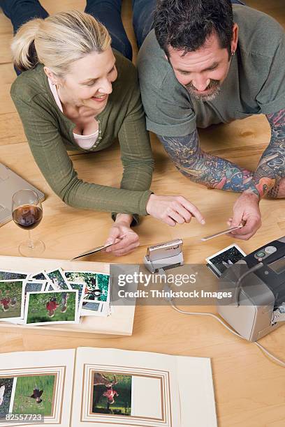 couple looking at photographs - photographie numérique photos et images de collection