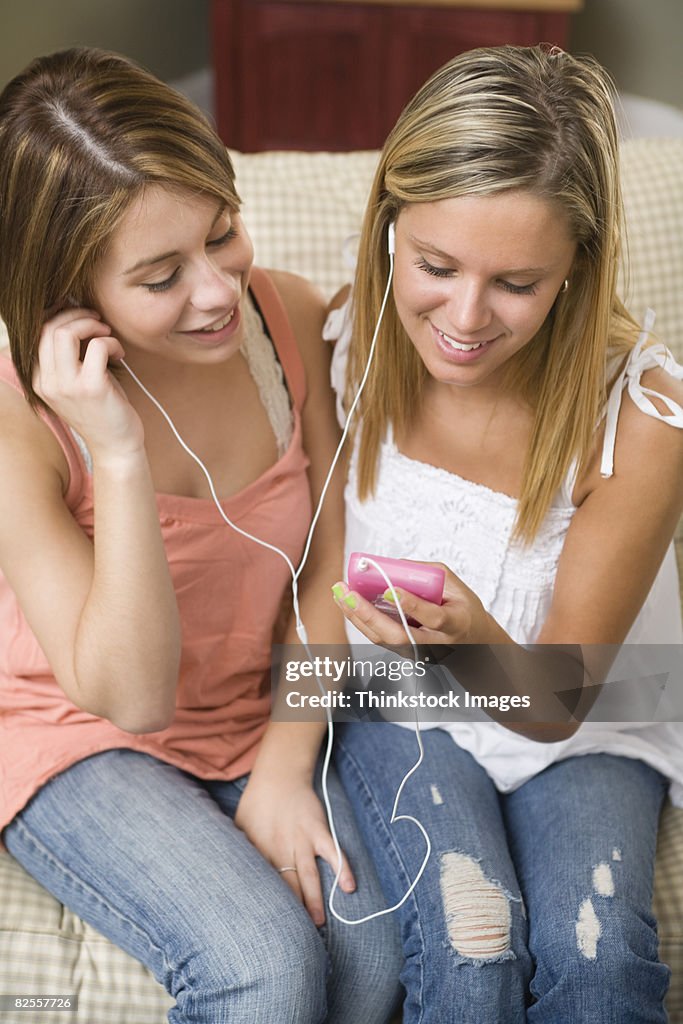 Teenage girls sharing mp3 player
