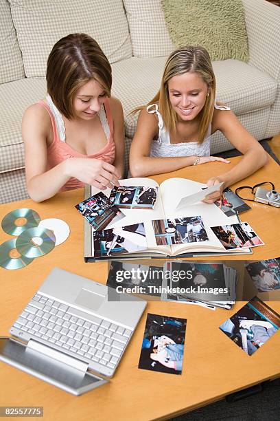 young adult women looking at photographs - photographie numérique photos et images de collection