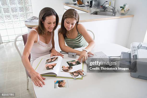 mother and daughter printing photographs - photographie numérique photos et images de collection