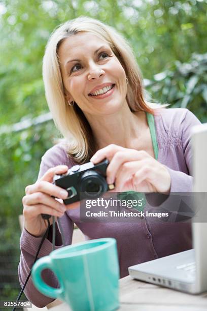 woman holding digital camera - photographie numérique photos et images de collection