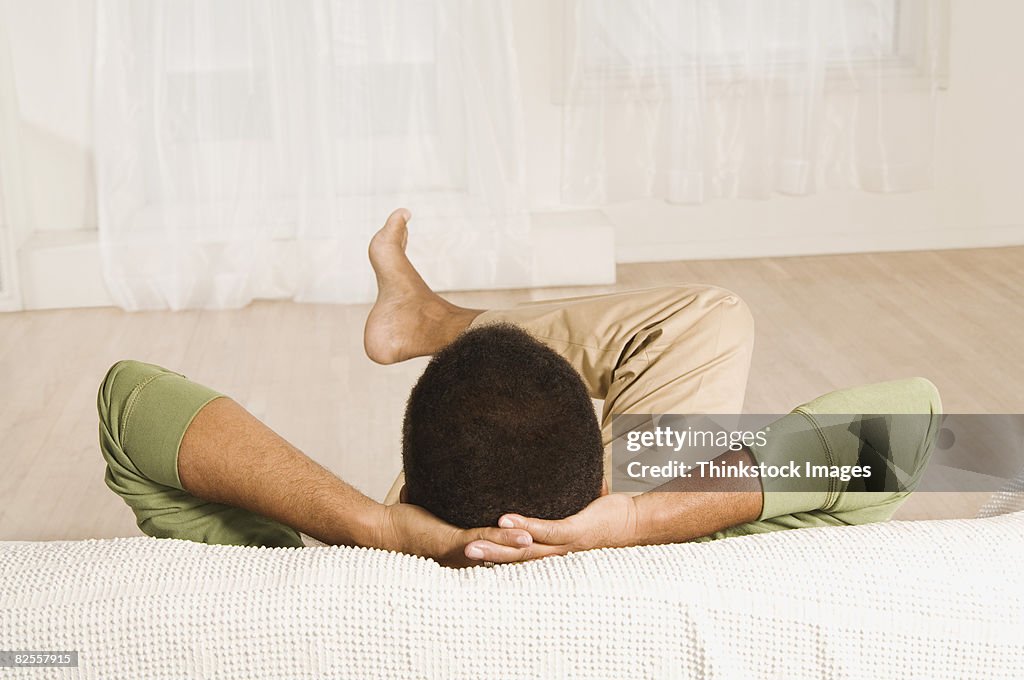 Man relaxing with hands behind head