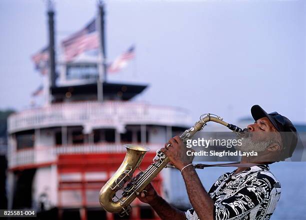 usa, louisiana, new orleans, saxophonist and paddle steamer - new orleans stock pictures, royalty-free photos & images