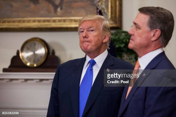 President Donald Trump and Sen. David Perdue listen as Sen. Tom Cotton makes an announcement on the introduction of the Reforming American...