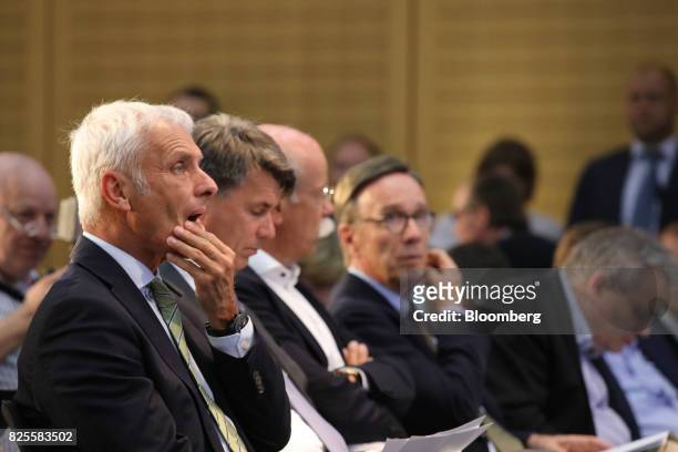 Matthias Mueller, chief executive officer of Volkswagen AG , left, listens while sitting beside Harald Krueger, chief executive officer of Bayerische...
