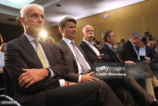 Matthias Mueller, chief executive officer of Volkswagen AG , left, lsitens while sitting beside Harald Krueger, chief executive officer of Bayerische...