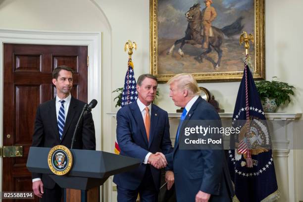 President Donald Trump shakes hands with Sen. David Perdue during an announcement on the introduction of the Reforming American Immigration for a...