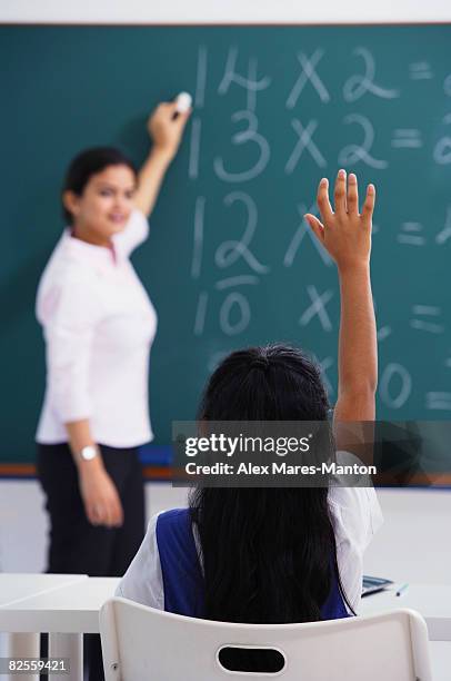 girl raises hand (back view) - teachers pet stock pictures, royalty-free photos & images