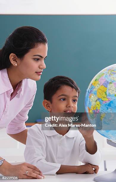 teacher and student look at globe - alex boys stockfoto's en -beelden