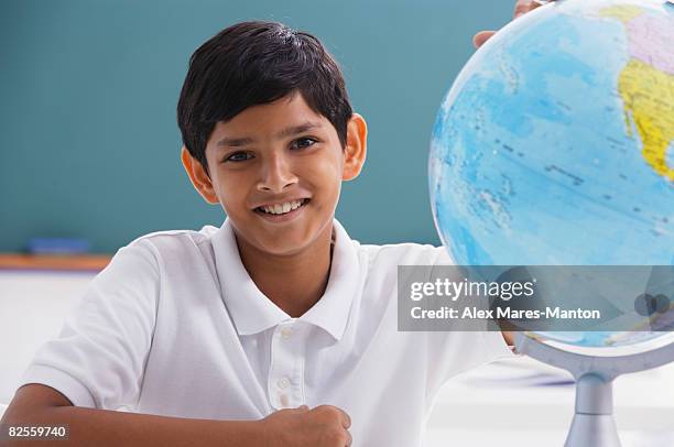 boy smiles at camera with globe - alex globe stock-fotos und bilder