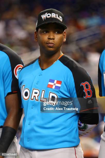 Rafael Devers of the World Team looks on during singing of the national anthem prior to the SirusXM All-Star Futures Game at Marlins Park on Sunday,...