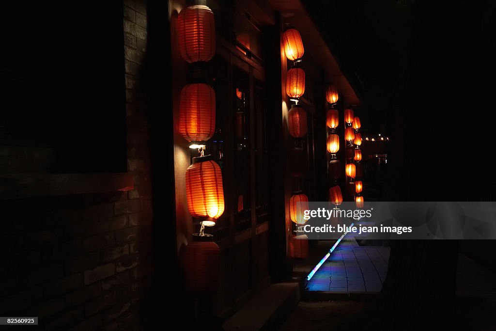 Lit lanterns hang in the night.