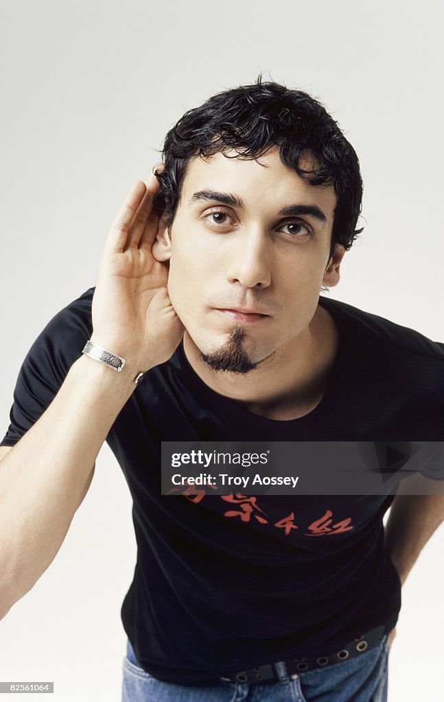 Man with hand to ear