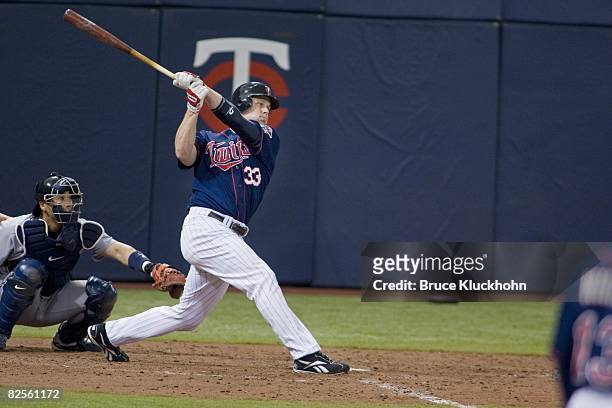 Justin Morneau of the Minnesota Twins hits a home run against the Seattle Mariners at the Humphrey Metrodome in Minneapolis, Minnesota on August 17,...