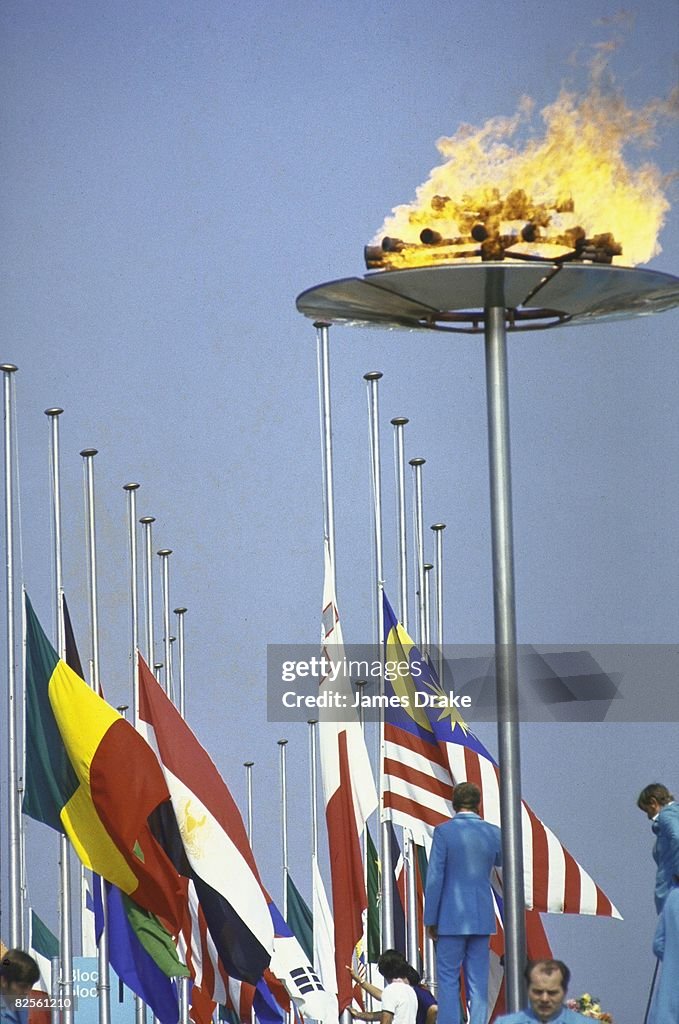 View of Olympic flame and cauldron as flags fly at half staff at
