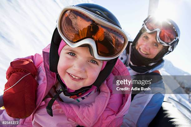 young girl and grandmother on chair lift - sport d'hiver photos et images de collection
