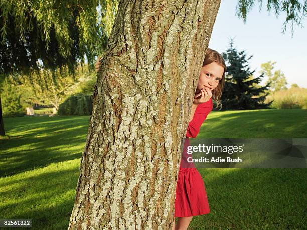 young girl hiding behind tree - hiding behind bush stock pictures, royalty-free photos & images