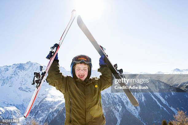 boy holding skis above his head - kids ski stock-fotos und bilder