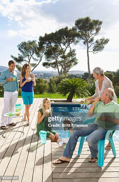 family on a wooden terrace by a pool - family vertical stock pictures, royalty-free photos & images