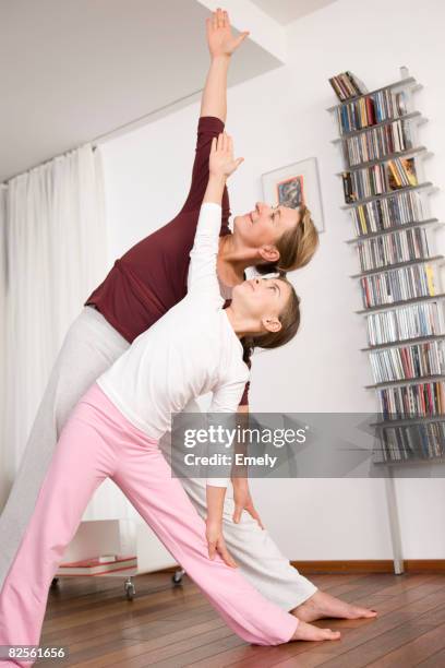 mother and girl doing yoga together - maternal triangle stock pictures, royalty-free photos & images