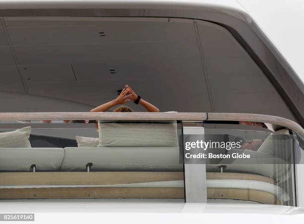 Ernesto Bertarelli, resting, and his wife, Kirsty, arms up on their superyacht, The Vava II, that is docked in Boston on Aug. 2, 2017.