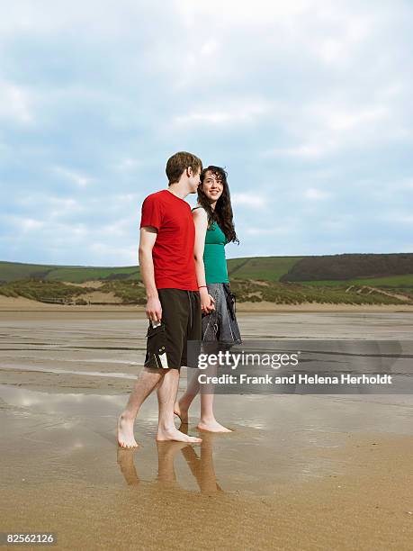 young couple walking on beach - croyde beach stock pictures, royalty-free photos & images