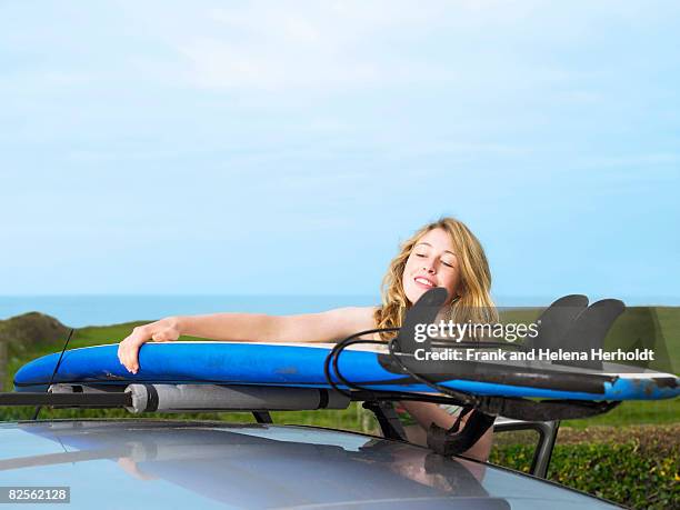 female taking surfboard off car roof - croyde beach stock pictures, royalty-free photos & images