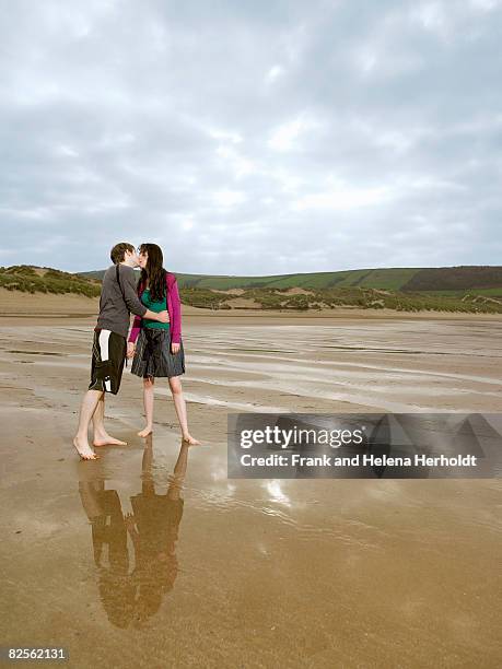 young couple kissing on beach - croyde beach stock pictures, royalty-free photos & images
