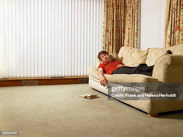 man sleeping on sofa - lazy sunday stock pictures, royalty-free photos & images