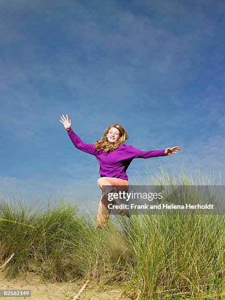 teenage girl jumping through grass - croyde beach stock pictures, royalty-free photos & images